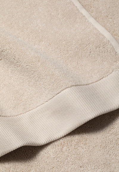 la serviette de bain beige détail côté.webp