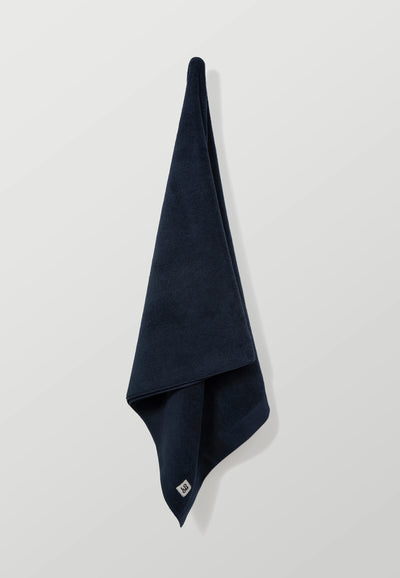 la serviette de bain bleu marine dépliée.webp