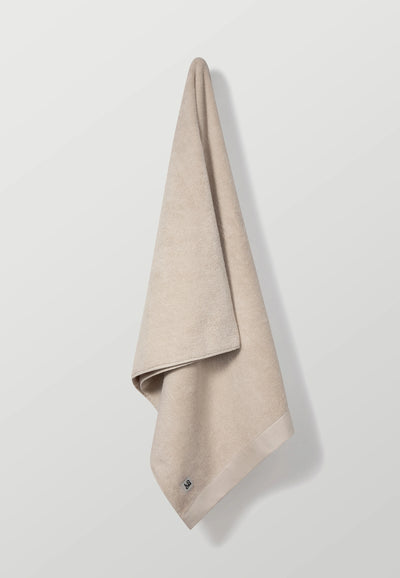 la serviette de bain beige main.webp