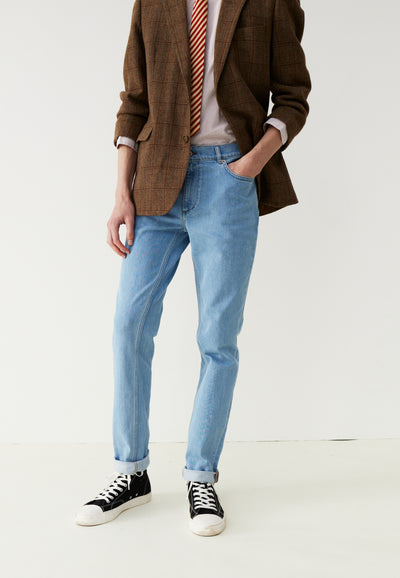 le jean bleu clair jambes main